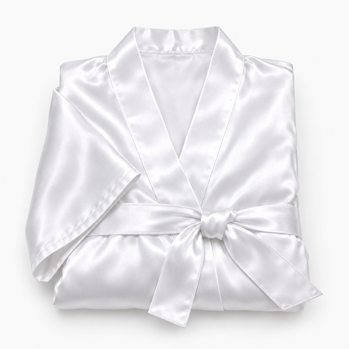 Peignoir en satin plié avec serviettes et gant exfoliant, noués d'un ruban comme un cadeau